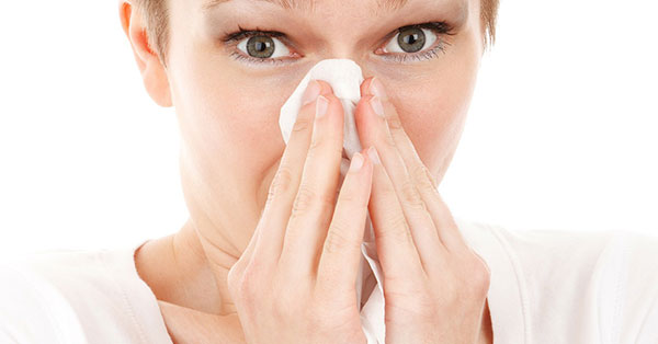 woman sick wiping nose