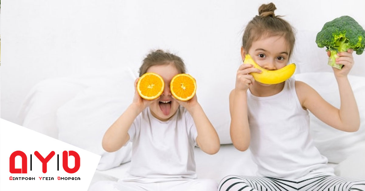 kids holding fruit in bed