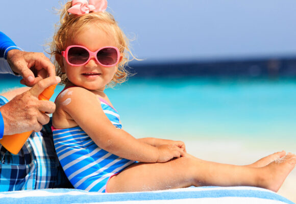 child-on-the-beach-putting-sunscreen