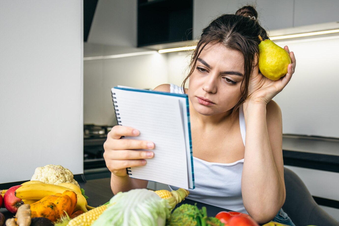 young-woman-kitchen-with-notebook-among-vegetables_169016-24203