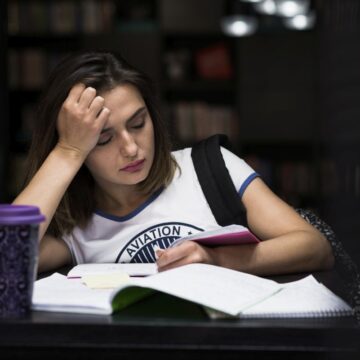 girl-sitting-table-with-notebooks-reading