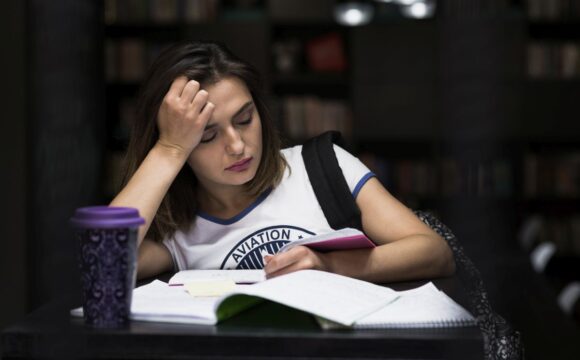 girl-sitting-table-with-notebooks-reading