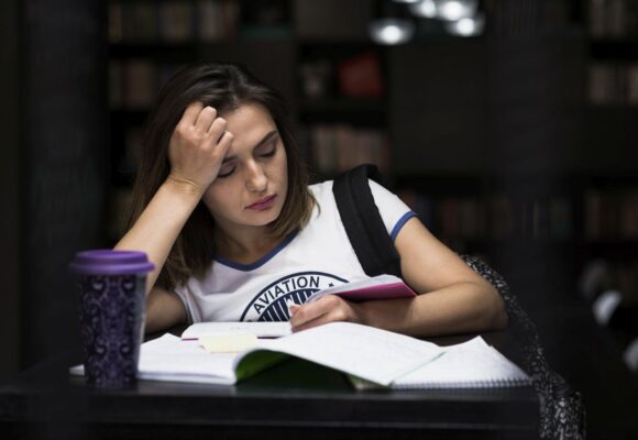 girl-sitting-table-with-notebooks-reading