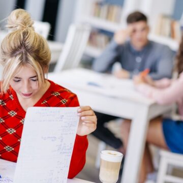 young-female-studying-with-notebook-library