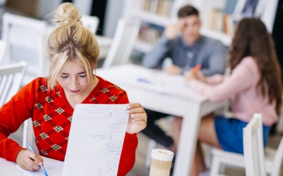 young-female-studying-with-notebook-library