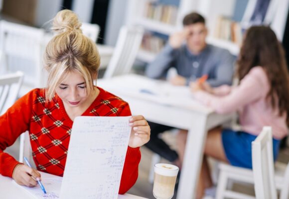 young-female-studying-with-notebook-library