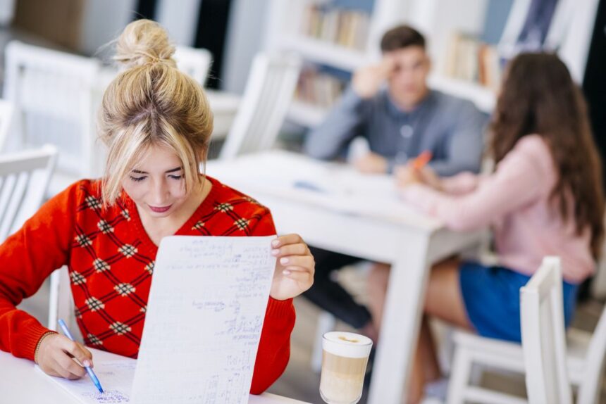 young-female-studying-with-notebook-library