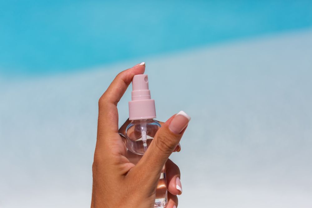 hands-holding-small-bottle-tanning-oil-liquid-blue-swimming-pool